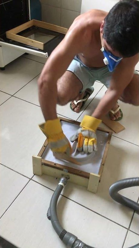 Cristiano vacuum forming a plastic sheet using his homemade vacuum forming machine